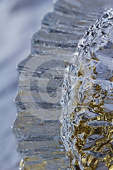 Macro modern art texture of bright abstract crystal glass reflecting brilliant golden color with a look of ice crystals or rock