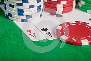 Macro pair aces and poker chips stack on table