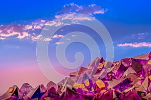Macro photo of amethyst crystals and sunset sky with clouds