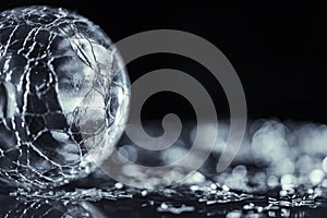 Macro photo of bright silver star and cracked glass sphere