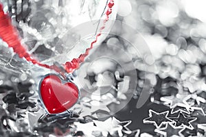 Macro photo of bright silver star and cracked glass sphere and red heart