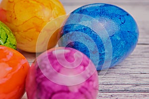 Macro photo of colored easter eggs on white wooden surface