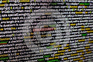 Macro photo of computer screen with program source code and highlighted CYBERSECURITY inscription in the middle. Script