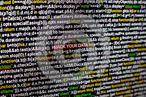 Macro photo of computer screen with program source code and highlighted HIJACK YOUR DATA inscription in the middle