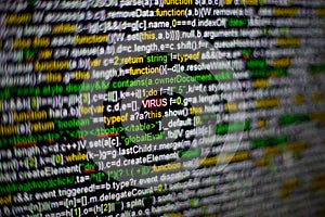 Macro photo of computer screen with program source code and highlighted VIRUS inscription in the middle. Script on the