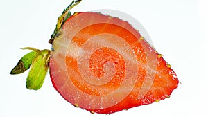 Macro image of cut ripe and sweet juicy strawberry half over white backgorund. Abstract background of berries and fruits