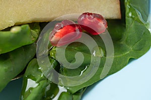 Macro photo. Drops of honey in a fruit plate. Spinach Fruit Salad with pomegr