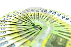 Macro photo of the European Union 100 EURO banknote, bills arranged in a fan, isolated on a white background, selective focus.