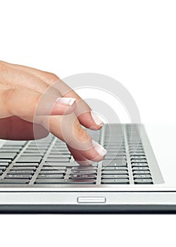 Macro photo of female hand typing on laptop