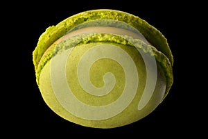 Macro photo of french green tea macaroon or macaron isolated on black background