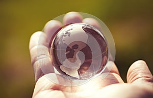 Macro photo of glass globe in human hand