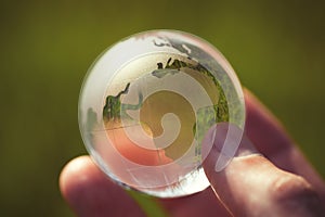 Macro photo of glass globe in human hand