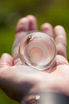 Macro photo of glass globe in human hand