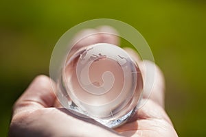 Macro photo of glass globe in human hand