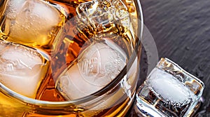 macro photo of glass with whiskey and ice cubes top view