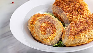 macro photo of Kiev-style cutlet in a plate on a white marble servery table photo