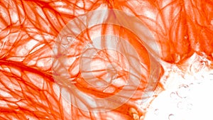 Macro photo of orange pulp structure. Pulp and juice of grapefruit over white background. Abstract background of exotic