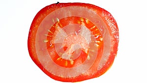Macro photo of red ripe tomato slice on white background. Abstract background of vegetables and fruits
