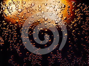 macro photo of the texture of bubbles in a glass of refreshing cold cola with ice