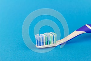 Macro photo of toothbrush isolated on blue background.