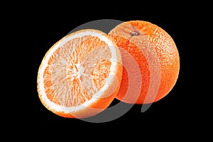 Macro photo of whole fruit orange and slice isolated on black background