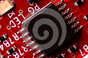 Macro Close-Up of Black Microchip on Red PCB