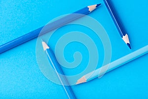 Macro photograph of several pencils of blue color on a paper background