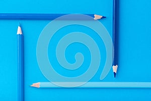 Macro photograph of several pencils of blue color on a paper background