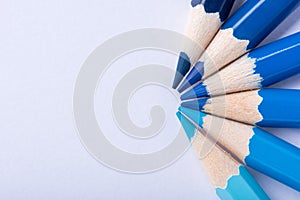 Macro photograph of several pencils of blue color on a white background