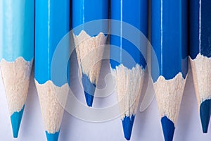 Macro photograph of several pencils of blue color on a white background