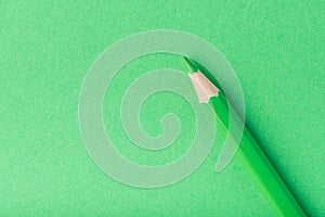 Macro photograph of several pencils of green color on a paper background