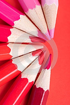 Macro photograph of several pencils of red color on a paper back