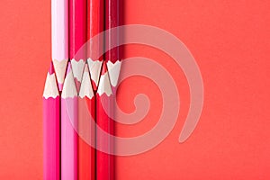 Macro photograph of several pencils of red color on a paper background