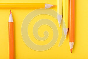 Macro photograph of several pencils of yellow and orange color o