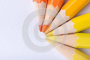 Macro photograph of several pencils of yellow and orange color o