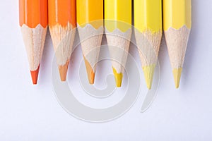 Macro photograph of several pencils of yellow and orange color o