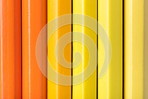 Macro photograph of several pencils of yellow and orange color o