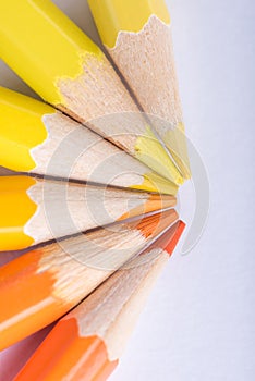 Macro photograph of several pencils of yellow and orange color o