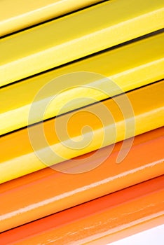 Macro photograph of several pencils of yellow and orange color o