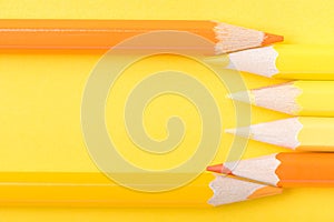 Macro photograph of several pencils of yellow and orange color o