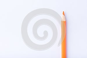 Macro photograph of several pencils of yellow and orange color on a white background