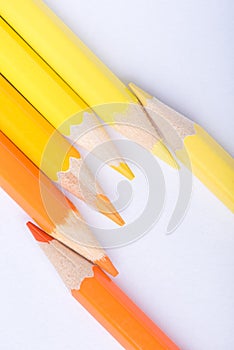 Macro photograph of several pencils of yellow and orange color o