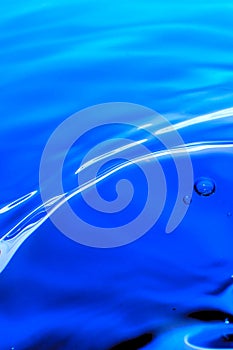 Macro photography of a blue water drop / ink drops splash and ripples, wet, conceptual for environmental, conservation, droug