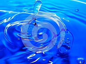 Macro photography of a blue water drop / ink drops splash and ripples, wet, conceptual for environmental, conservation, droug