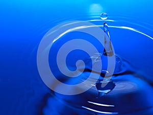 Macro photography of a blue water drop / ink drops splash and ripples, wet, conceptual for environmental, conservation, droug