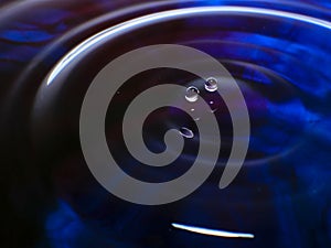 Macro photography of a dark blue water drop / ink drops splash and ripples, wet, conceptual for environmental, conservation, droug