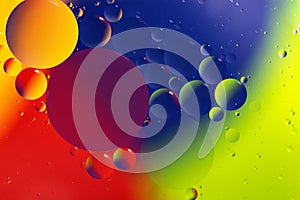 Macro photography of the drops on the water surface.Multicolored vibrant background.Cosmic circles looks like molecula structure. photo