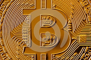 Macro photography of a golden yellow metal bitcoin. Close up shiny metal texture. Abstract business and modern technology backgro