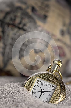 Macro photography of old gold pocket watch background a old world map..