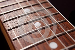 Macro photography to a six electric guitar strings and wooden fretboards